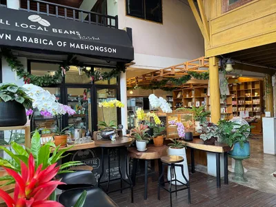 Orchids on timber tables under an All Local Beans awning with a coffee counter behind