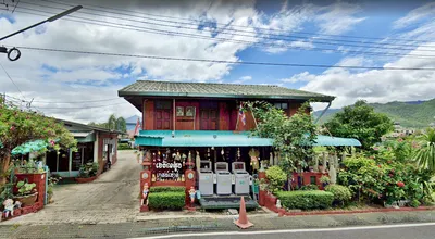 Teak roadside guesthouse hung with wind chimes above three drink machines