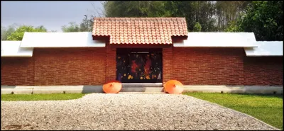 Brick gallery wall with a tiled gateway, painted panel and two orange parasols