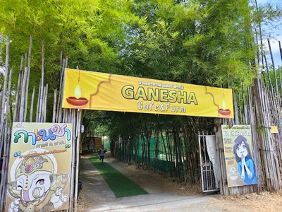 Yellow Ganesha Cafe and Farm banner over a bamboo-lined entrance path