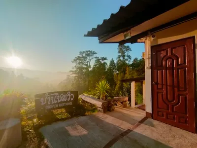 Goodview Guesthouse sign and a guest-room door with the sun rising over misty hills