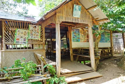 Open bamboo schoolhouse hung with teaching posters