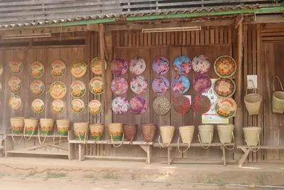 Painted bamboo sun hats and woven back baskets ranged along a timber shopfront