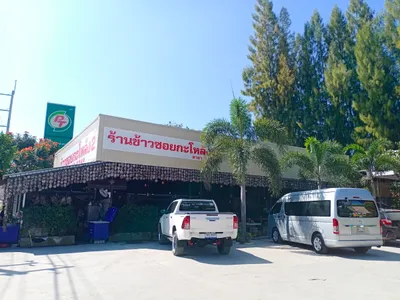 Khao soi restaurant hung with rows of coconut shells beside a petrol station