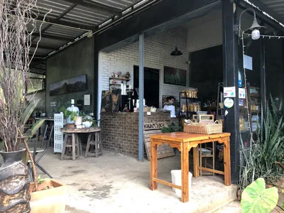 Open-fronted brick and steel cafe with Khuamsukh chalked on the counter