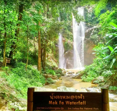 Twin falls dropping into a pool behind the Mok Fa Waterfall sign