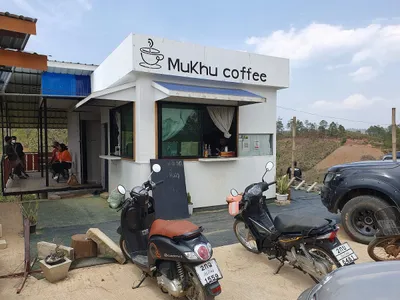 White Mukhu Coffee kiosk with bikes parked outside on dry open hills
