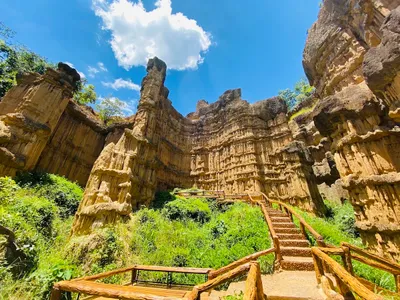 Fluted sandstone cliffs rising above a log-railed stairway