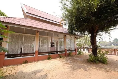 Single-storey guesthouse with a red tiled roof and a glazed veranda