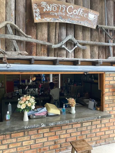 Carved wooden Rimthan Coffee sign above an open brick service window