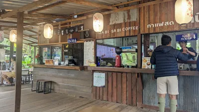 Customer ordering at the reclaimed timber and tin Wabi Sabi Coffee counter under paper lanterns